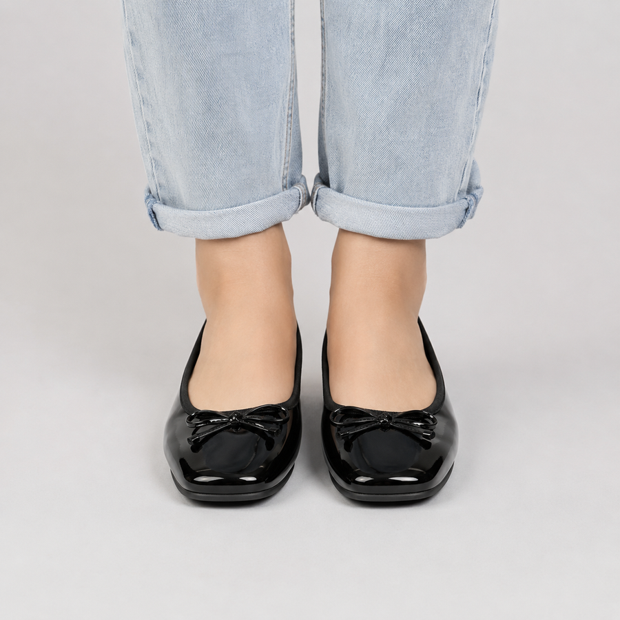 Ballerines femme noires à bout ouvert avec nœud portées avec un jean clair