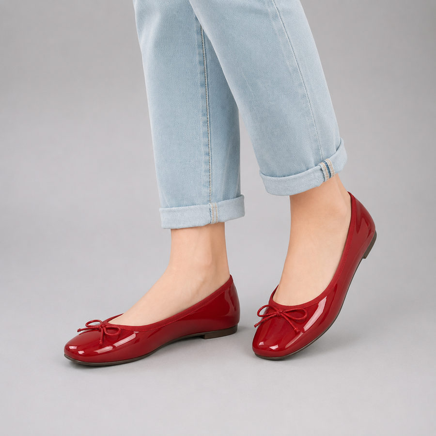 Ballerines rouges à bout rond avec nœud papillon portées de côté