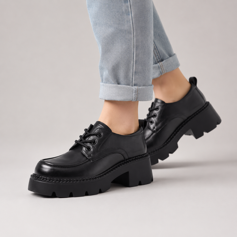 Chaussures en cuir noir à lacets pour femme portées avec un jean clair