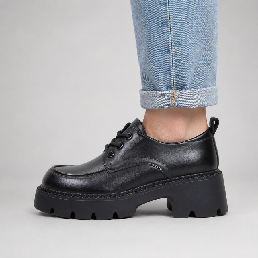 Vue latérale des chaussures en cuir noir à lacets pour femme avec semelle épaisse
