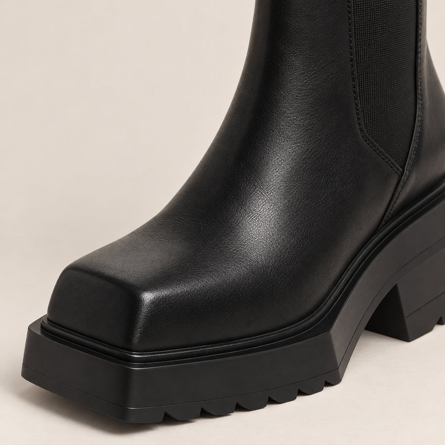 Bottines Chelsea Femme - Bout Carré Talon Bloc Effet Cuir - Noir - gros plan bout carré et semelle sur fond beige