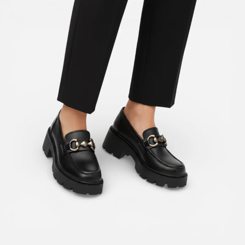 Mocassins plateforme noirs à chaînette argentée portés avec une tenue élégante